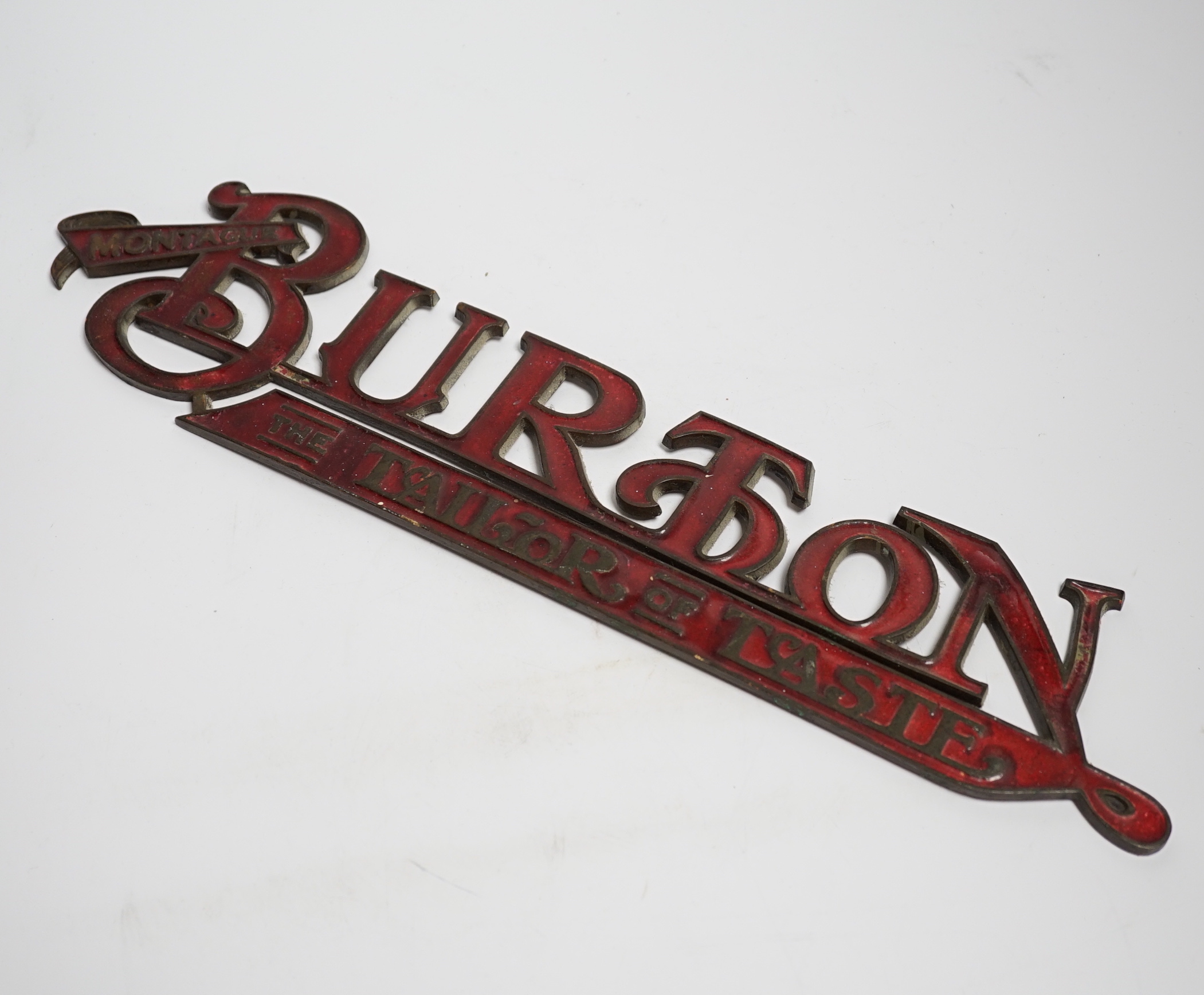 An enamelled bronze 'Montague Burton The Tailor of Taste' shop sign, 41cm wide